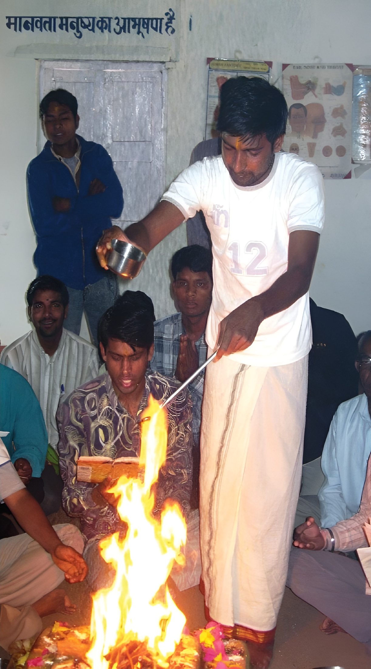 The pūrṇāhuti at the Gayatri havan. The final offering poured into the fire at a Gayatri havan in the same classroom, 17